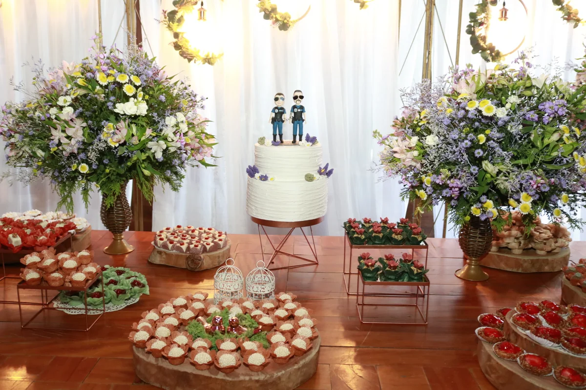Mesa de casamento com bolo branco e arranjos florais