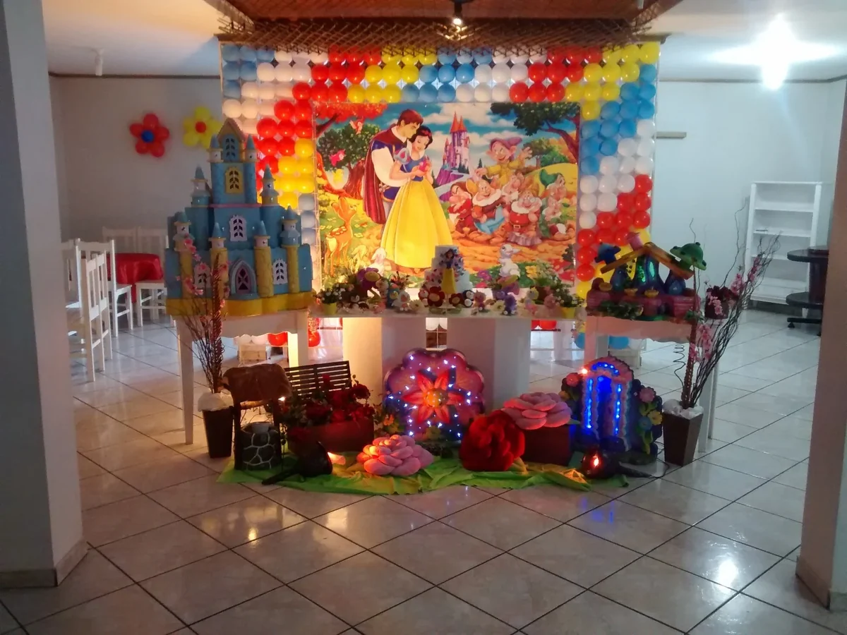 Decoração de festa infantil com tema Branca de Neve, castelo, flores e painel de balões.