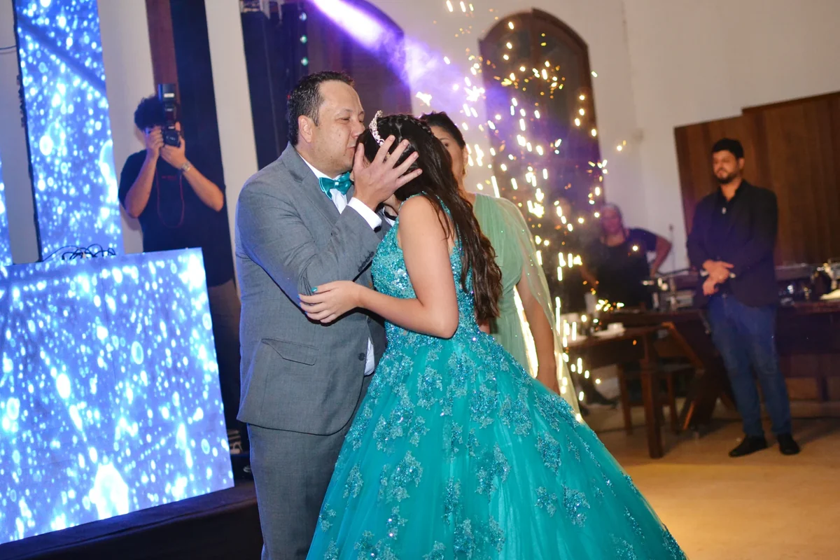 Giovana recebe um beijo na testa durante a celebração dos seus 15 anos.
